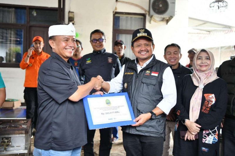 Sekda Provinsi Jawa Barat, Herman Suryatman saat menyerahkan bantuan logistik dari Pemdaprov Jabar senilai Rp 289,6 juta dalam bentuk barang dan kebutuhan pokok melalui Dinas Sosial serta BPBD  di Kecamatan Cimanggung, Kabupaten Sumedang, Minggu (16/3/2025).